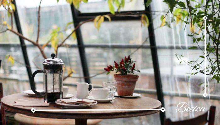 round brown wooden table with french press on top with white ceramic teacup beside round brown wooden table with french press on top with white ceramic teacup beside
